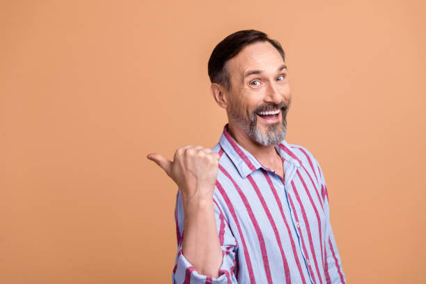 Portrait of impressed person with white gray beard striped shirt directing at big sale empty space isolated on pastel color background stock photo
