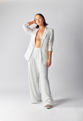 Suit, style and asian woman with fashion in portrait or confident in studio or white background with luxury outfit. Trendy, elegance and girl with vintage or classy, retro, creative or cool clothes.