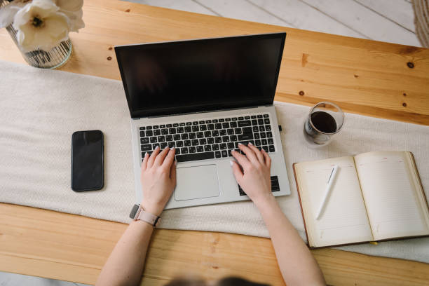 istock Mockup image blank screen laptop computer, cell phone with background for advertising text. Hands woman using laptop on table. Writing typing. Freelance concept. Work home. Marketing, learning, design 1573886776