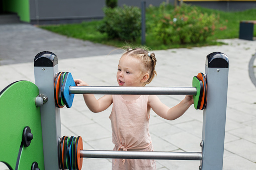 Little toddler girl having fun at playground. Concept of kindergarten, baby development and early years