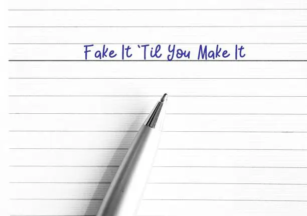 Photo of Pen on note book paper planner written Fake It Til You Make It , act the way into new habits until that behavior will become more of a habit and begin to come more easily