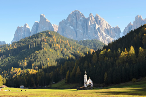 The famous church of San Giovanni in Ranui (Sankt Johann) in front of the Geisler or Odle Dolomites mountain peaks in Santa Maddalena (Sankt Magdalena) in the Val di Funes in Italy.