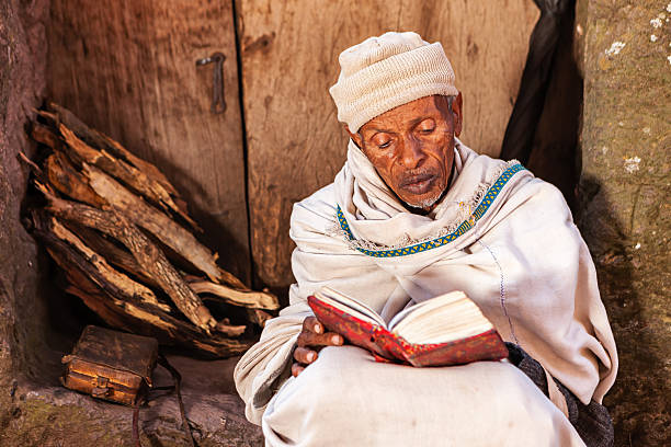 monge ler o livro de oração perto de lalibela de igrejas - travel ethiopia imagens e fotografias de stock