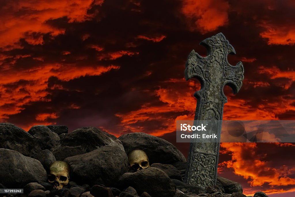 Forefathers Celtic cross and human skulls under a fiery sky. Dark Stock Photo