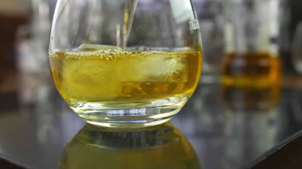 istock Pouring Whiskey into Drink Glass with Ice Cubes Slow Motion 1573935214