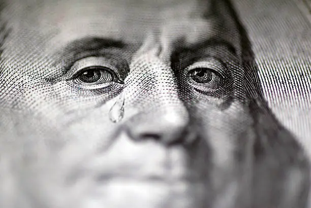 Photo of Tear falling from face on US dollar bill, close-up