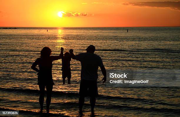 Silhouette Der Eltern Hält Kind Bei Sonnenuntergang Am Strand Stockfoto und mehr Bilder von 12-17 Monate