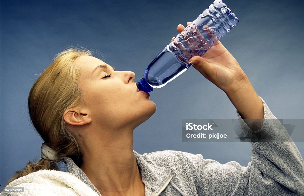 Kobieta pije wodę z butelki - Zbiór zdjęć royalty-free (Blond włosy)