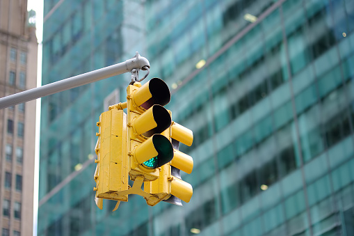 Yellow Traffic Light on background of skyscrapers, Manhattan, New York, USA. Green signal.