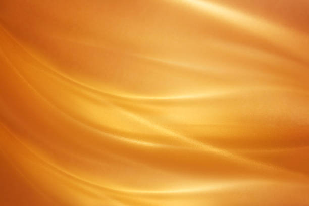 Brushed Gold Sheet of warped brushed gold. Lighting and reflections make it look like swirls of melted gold. Light and shadows created with lighting techniques. caramel photos stock pictures, royalty-free photos & images