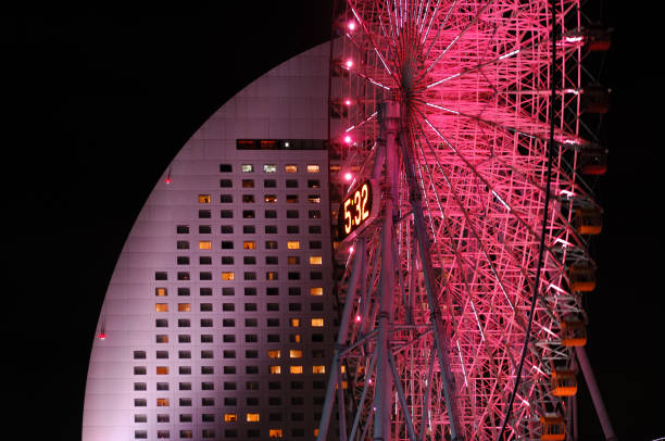 The famous giant ferris wheel of Yokohama's futuristic Minato Mirai 21 district and the close by luxury hotel at night. 