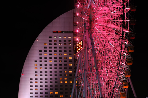The famous giant ferris wheel of Yokohama's futuristic Minato Mirai 21 district and the close by luxury hotel at night. 