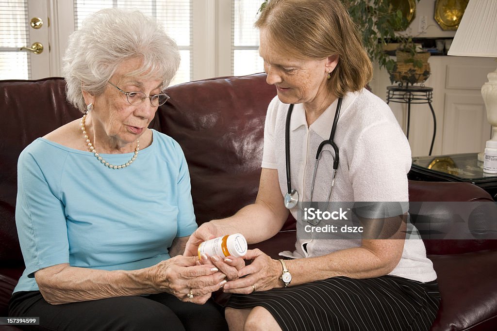 Casa Saúde profissional médico ajuda a mulher idosa com remédios - Foto de stock de 50 Anos royalty-free