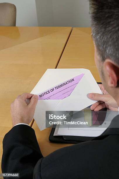 Man Opening An Envelope Containing Notice Of Termination Stock Photo - Download Image Now