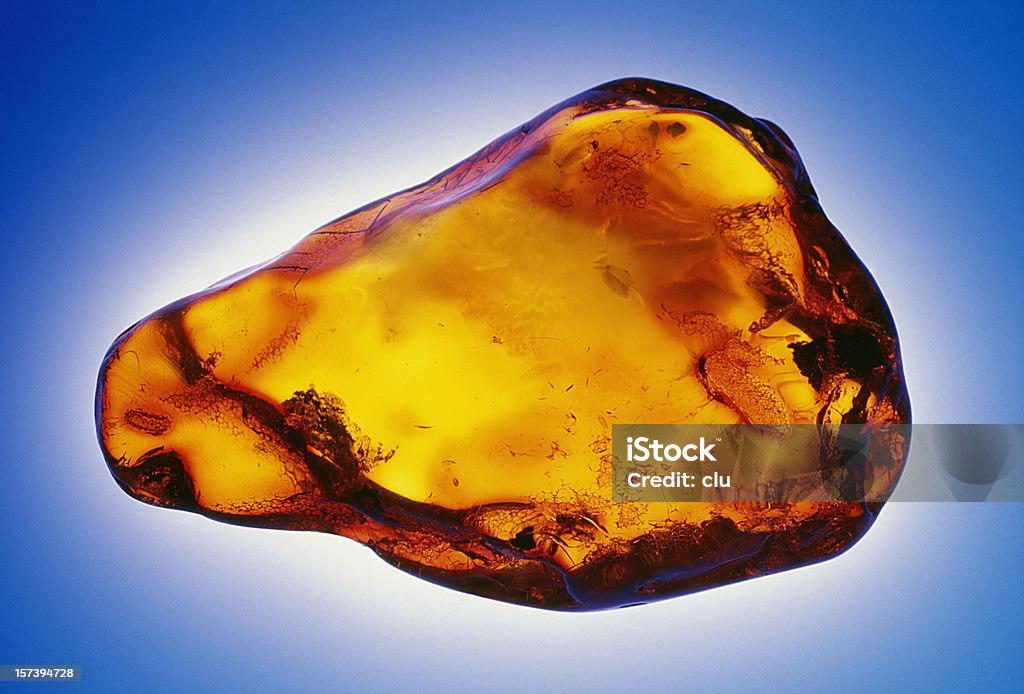 Grande pietra ambra isolato su sfondo blu - Foto stock royalty-free di Arancione
