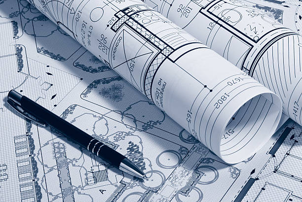 istock Picture of architectural plans rolled up next to a pen 157394745