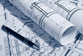 Picture of architectural plans rolled up next to a pen