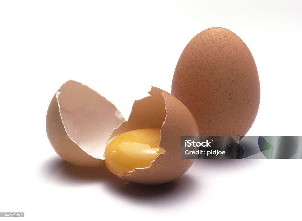 raw eggs close up on two raw eggs, one broken, one whole isolated on white background Egg - Food Stock Photo