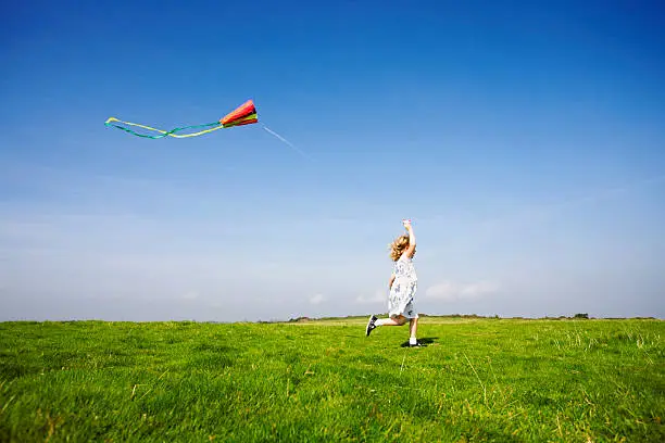 A young girl flying her kite