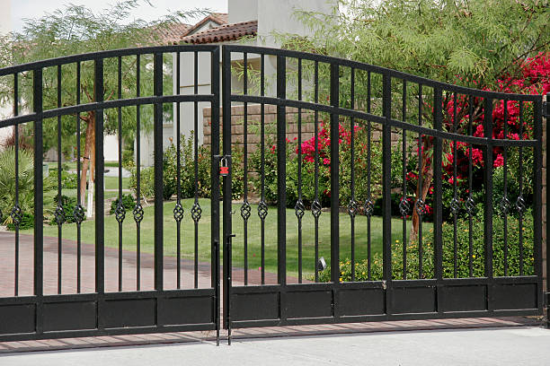 Wrought Iron Security Gates Large decorative Wrought Iron gates on condo complex. Red Lock and Red Flowers. wrought iron stock pictures, royalty-free photos & images