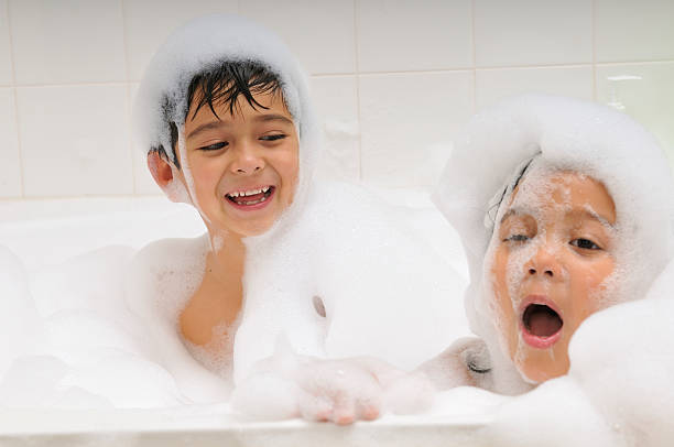 Baby boy with soap foam or shampoo on his head