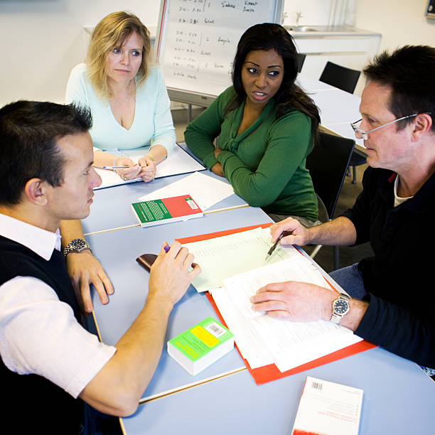 istock adult education: mature students working together in a team meeting 157395892