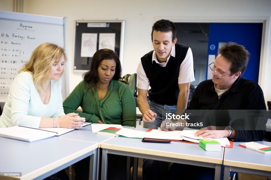 Educação de Adultos: Professor ajudando um grupo de estudantes maduros - Royalty-free Professor Foto de stock