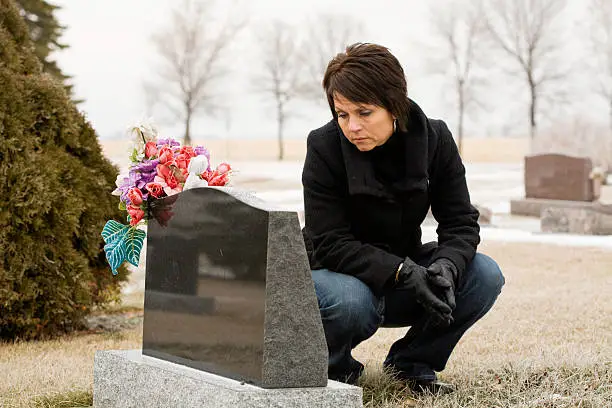 A woman grieving and remembering a loved person on a dreary winter day.