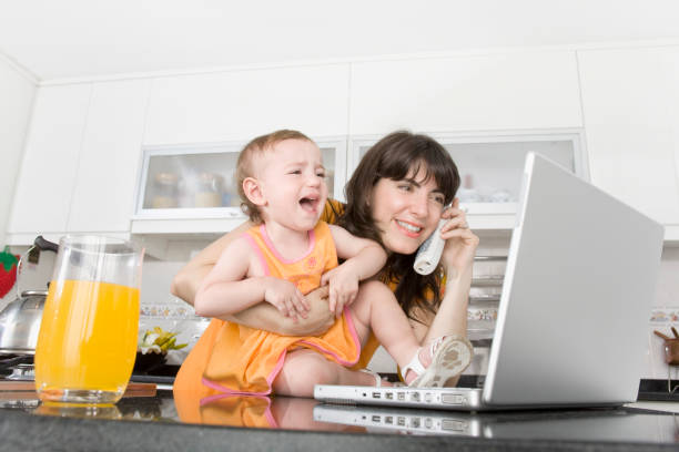 mãe e bebê chorando com laptop na cozinha - mom yelling on phone - fotografias e filmes do acervo
