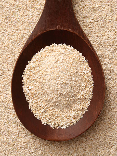 Oat bran Top view of wooden spoon full of oat bran bran stock pictures, royalty-free photos & images