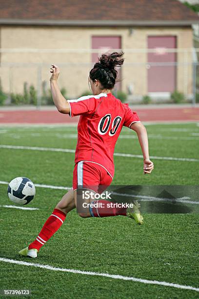 Joven Mujer Jugador De Fútbol En Rojo Chases De Saltando De Bola Foto de stock y más banco de imágenes de Actividad