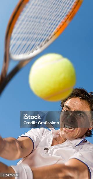 Foto de Céu Azul Sobre Jogador De Tênis Chutando A Bola e mais fotos de stock de Adulto - Adulto, Adulto de idade mediana, Atividade