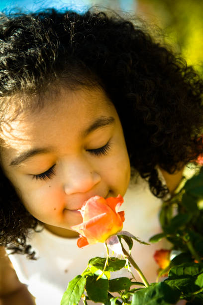 istock Child with Eyes Closes Smelling Flowers 157396649