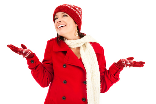 Photo of a young woman in red wool jacket, scarf and mittens, holding her hands up as if wishing for snow.