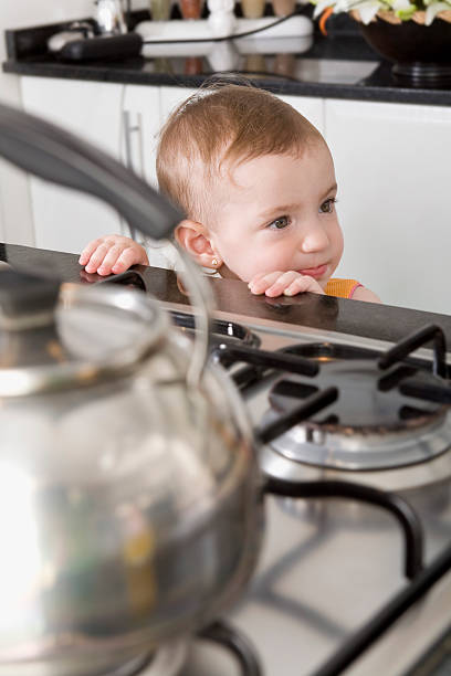 istock Baby in danger at kitchen stove 157396941