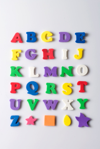 Bright multi-colored English alphabet lies on a white background in the form of a circle. In the middle is a math example.