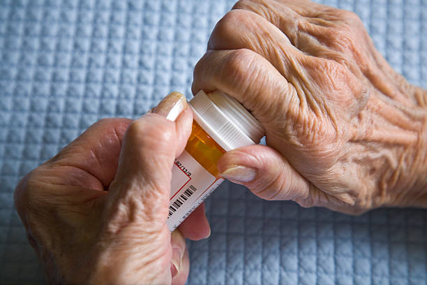 istock arthritis hands trying to open prescription medicine pill bottle 157397050