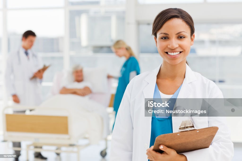 Sonriente mujer médico en hospital ambiente - Foto de stock de 20-24 años libre de derechos