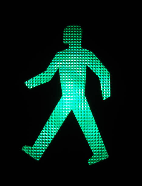 An illuminated green LED image of a walking person green bright crosswalk traffic light green light stoplight photos stock pictures, royalty-free photos & images