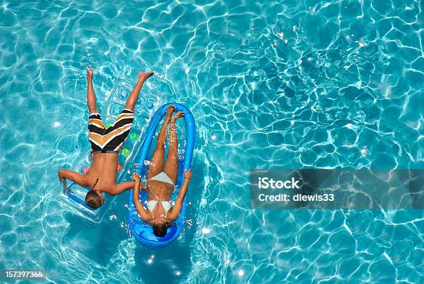 Joven Pareja En La Piscina Foto de stock y más banco de imágenes de Parejas - Parejas, Colchón inflable, Piscina