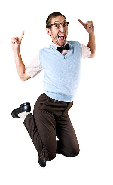 Jumping Happy Nerd Guy Isolated on White Nerdy IT student young man jumps in excitement; isolated on a white studio background.  Vertical with copy space. nerd stock pictures, royalty-free photos & images