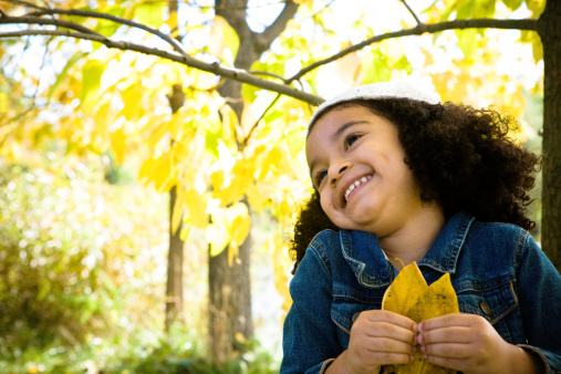 This little girl is very happy in a fall portrait.