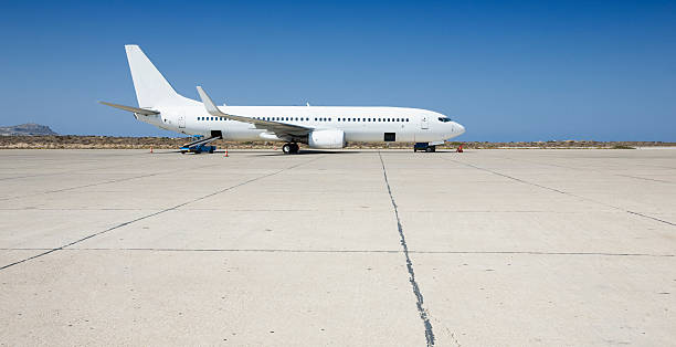 Airplane loading on airport Filling cargo by side profile of an airplane on tarmac. airfield stock pictures, royalty-free photos & images