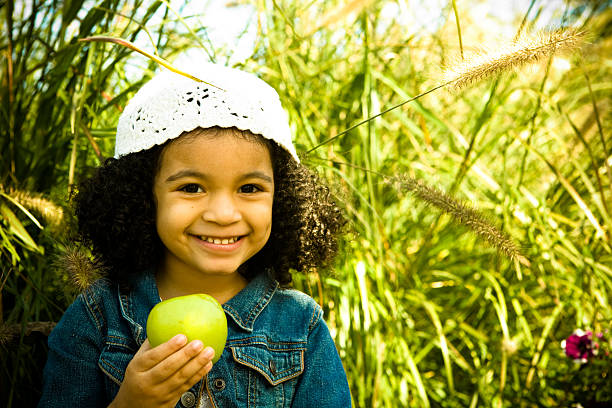 маленькая девочка с зеленым яблоком - apple eating little girls green стоковые фото и изображения