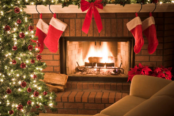 istock comfortable sofa by blazing fireplace and decorated Christmas tree 157398360