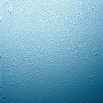 Condensation drips down a frosted blue surface