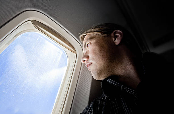 istock Close-up of passenger looking out through window on a plane 157399401