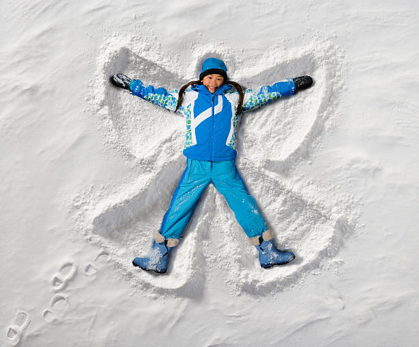Snow Angel Young girl creates a snow angel. snow angels stock pictures, royalty-free photos & images