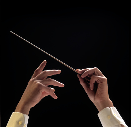 Conductors hands with baton on black background