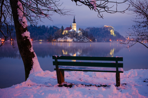 Evening view of the Lake Bled located in Slovenia Europe. There is a Church on the Island and ancient castle on top of a rock.